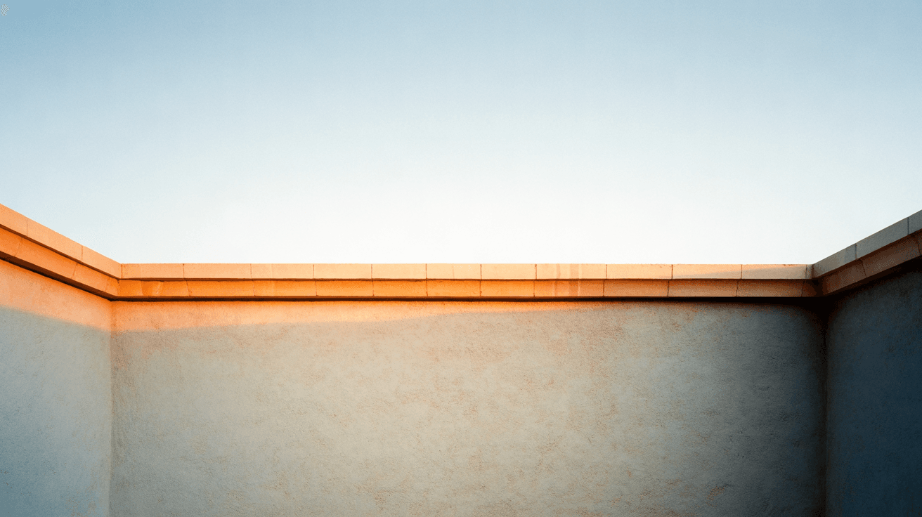 Generated image: a level chalk stucco wall under a travertine cap against a pale late-afternoon sky